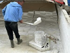 Shovelling slaked lime onto the ground.