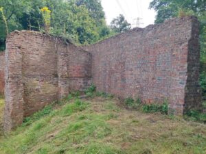 Londonthorpe firing wall after graffiti removal and showing deterioration of brick wall heads on the right-hand bay.